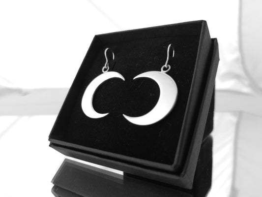 Sterling Silver crescent moon earrings on a black jewelry box with a white background