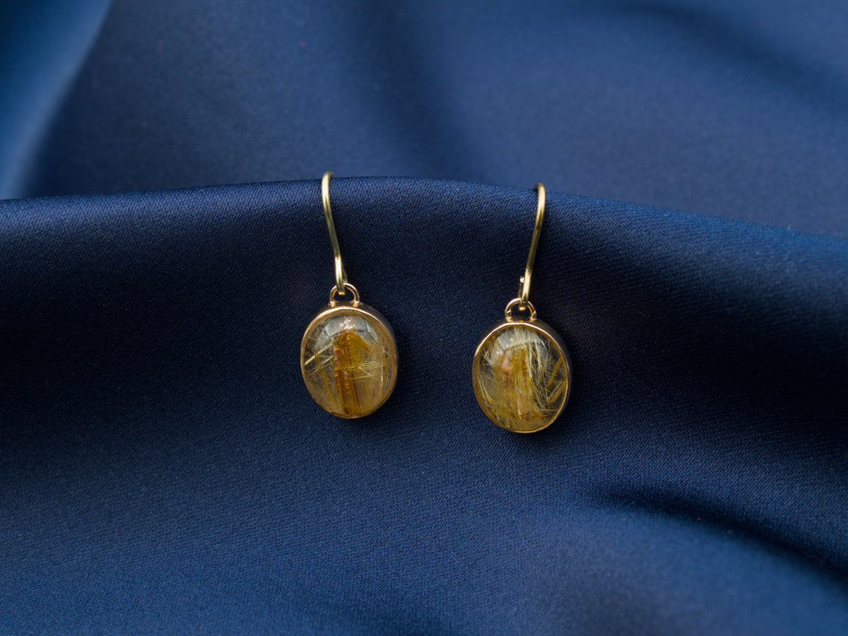 A pair of 14 karat gold drop earrings with gold rutile quartz stones